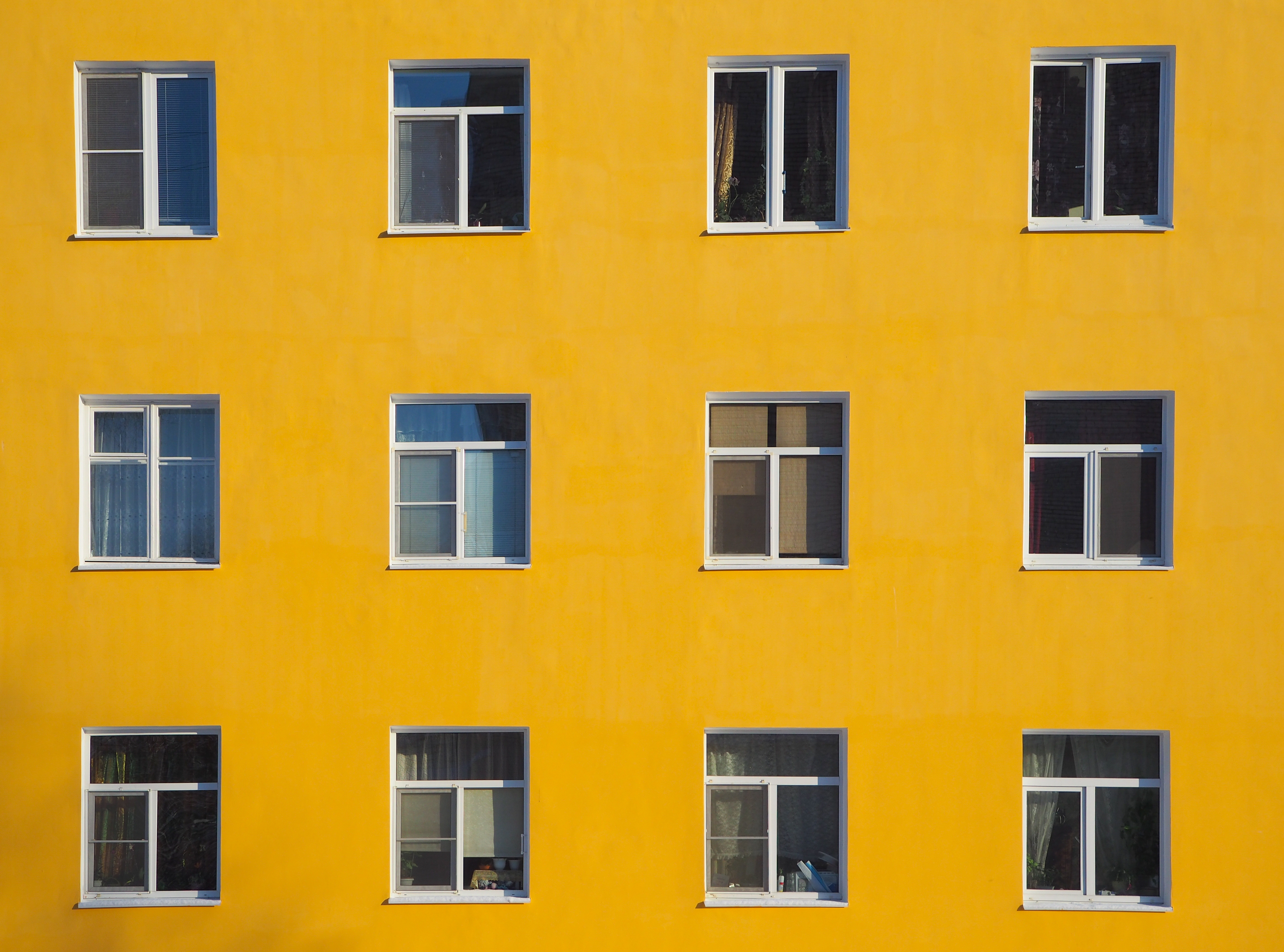 Yellow house wall with windows. The architectural background.